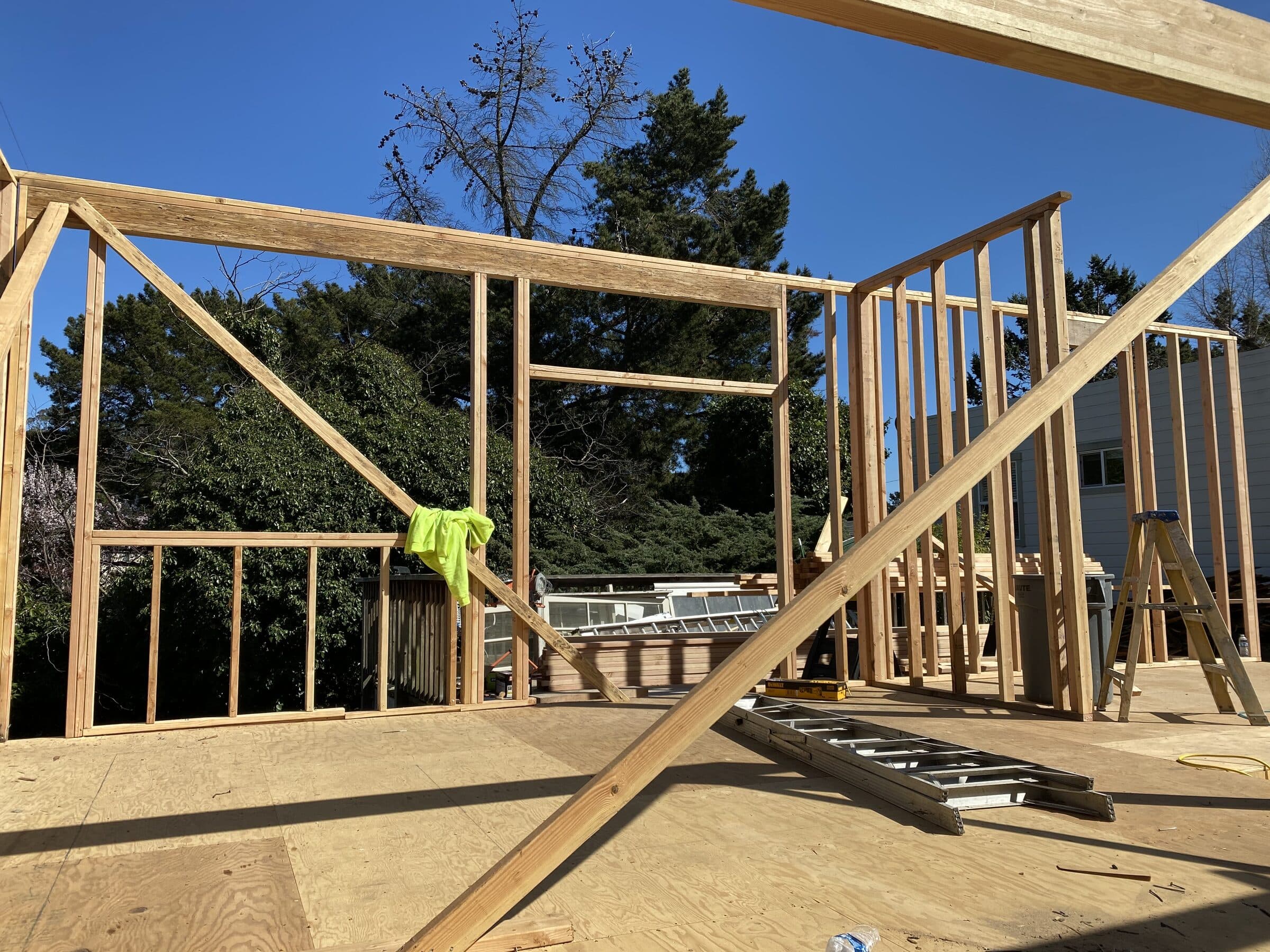 New stud walls framed up on the plywood deck against a clear sky